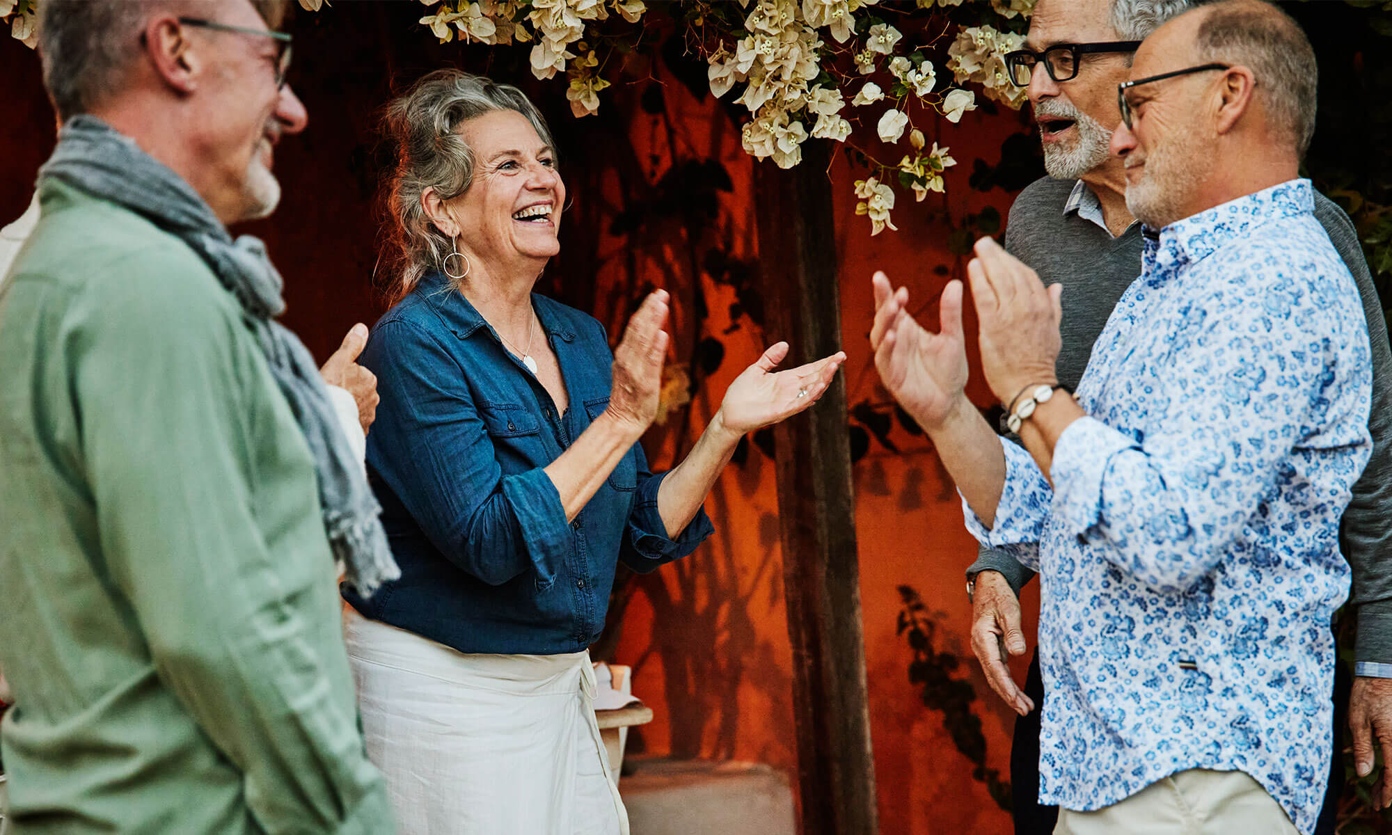 Friends gathered outside clapping and laughing together.