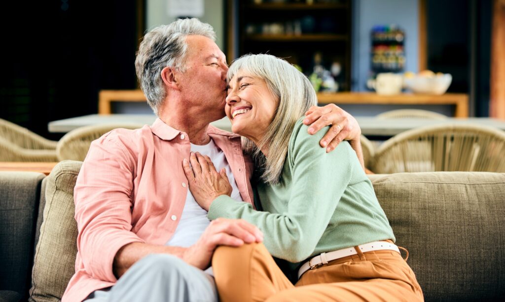 senior couple snuggling on couch