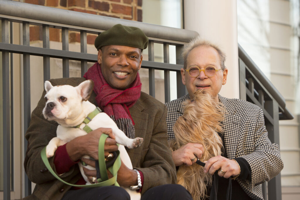two men holding dogs